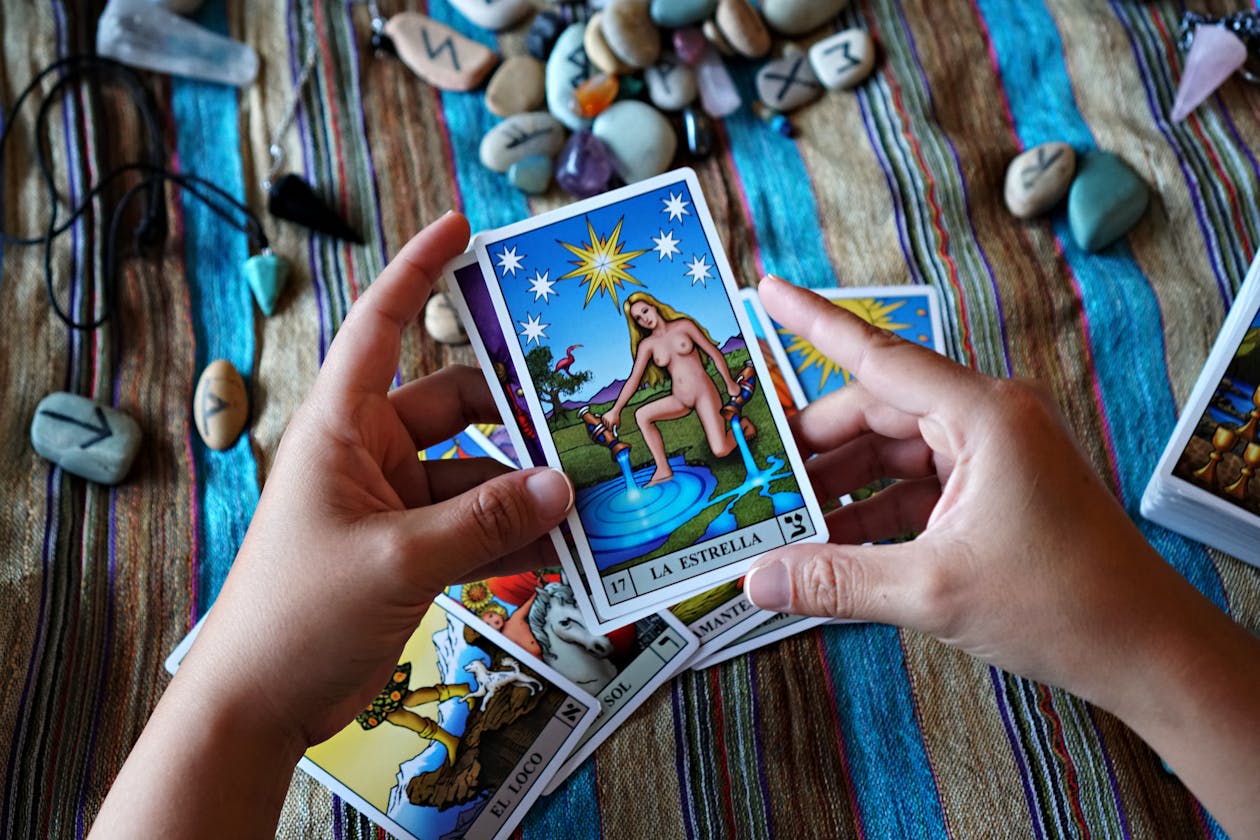 Hands holding a tarot card representing tarot archetypes and the human journey of psychological growth