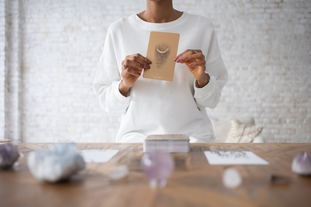 Person holding a tarot card for self-reflection using tarot archetypes for personal growth