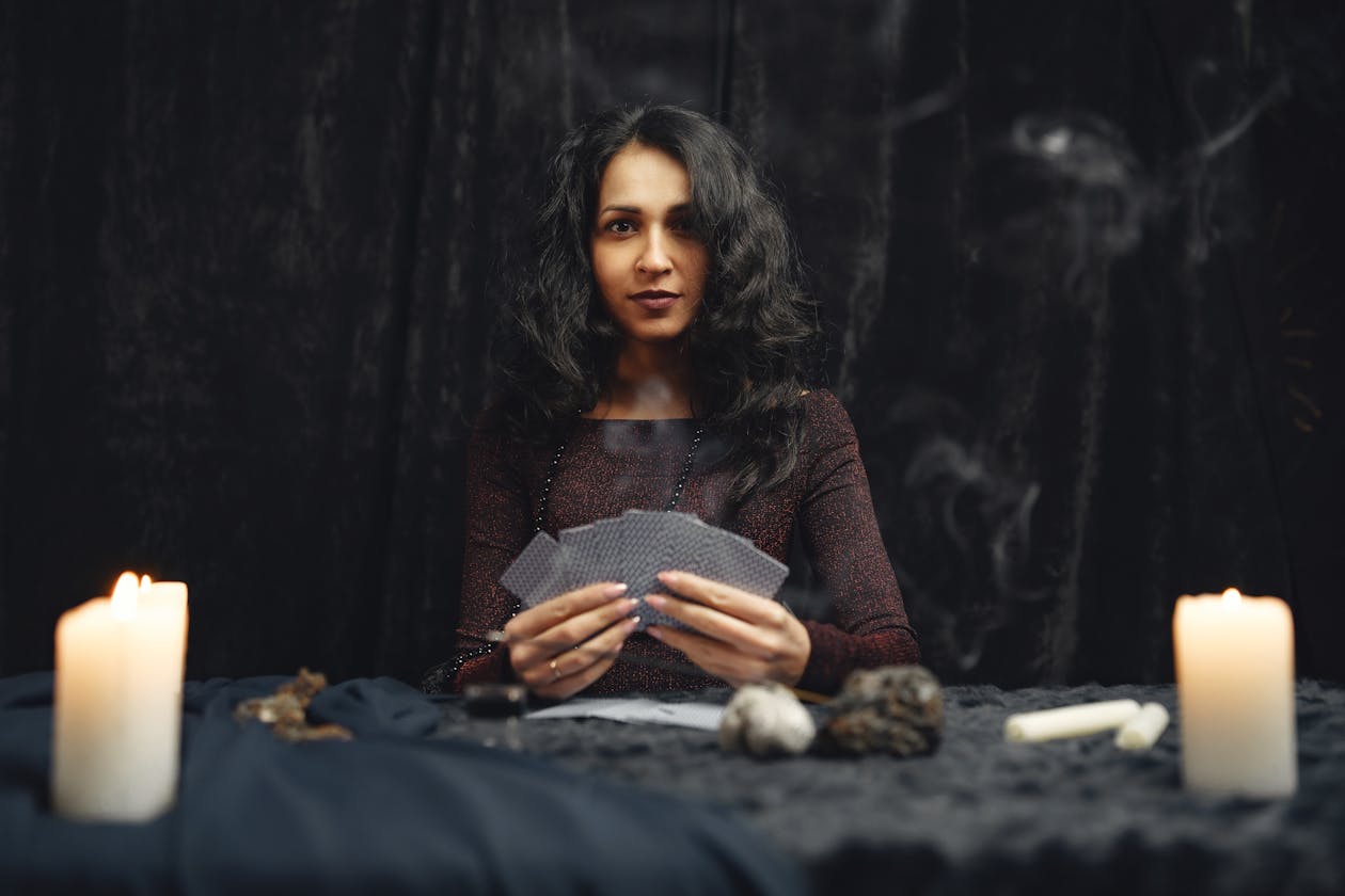 Woman holding tarot cards demonstrating pareidolia and psychological projection during a reading