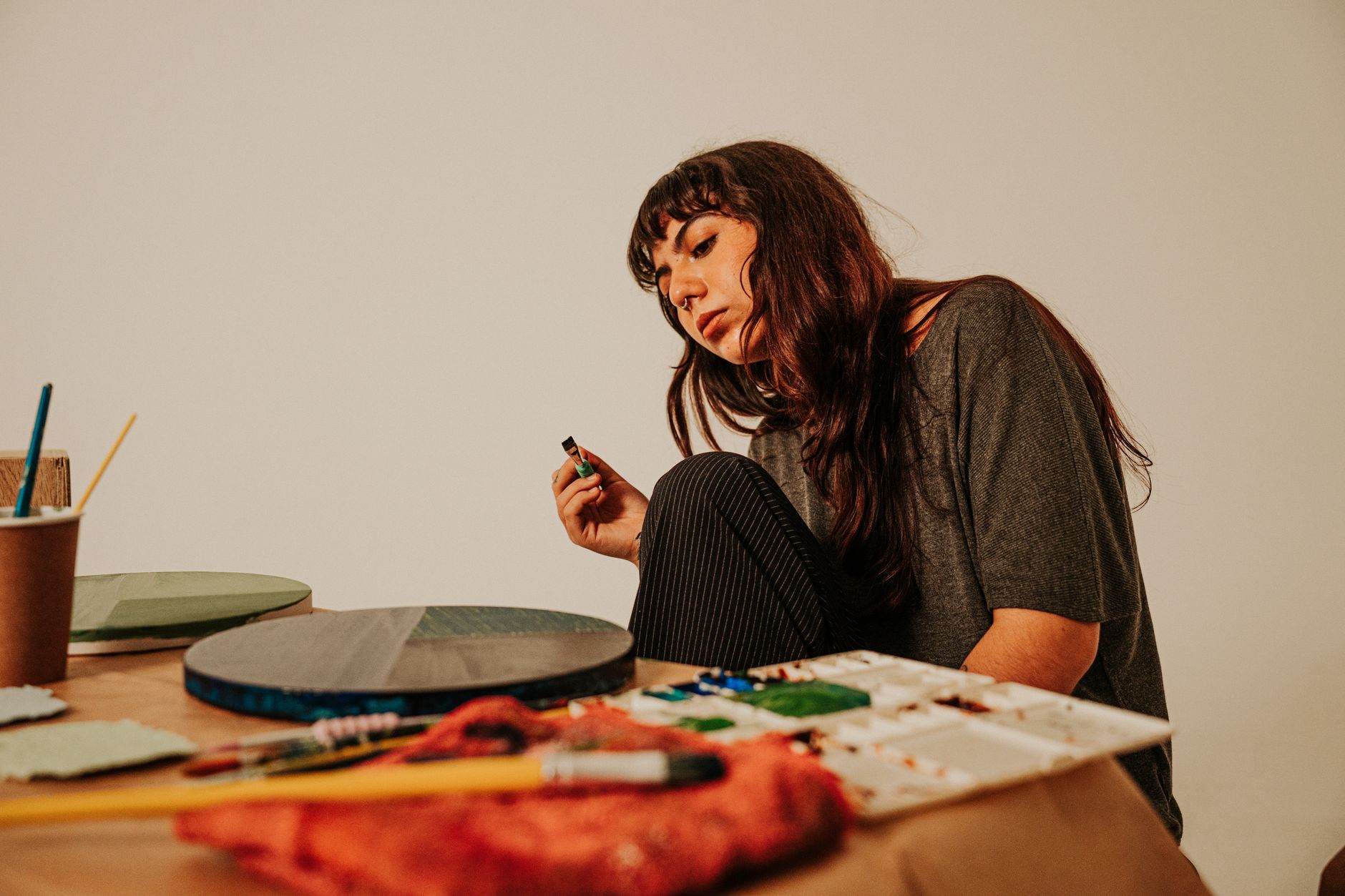 An artist at work in her studio, where human-made certification marks human authorship as a premium in an AI-flooded market