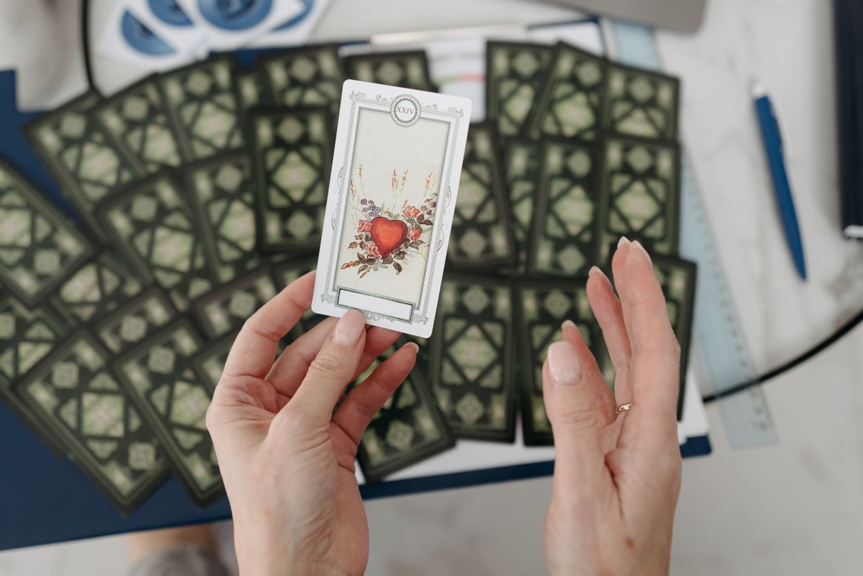Hands holding a tarot card during a pareidolia reading demonstrating the describe dont interpret method